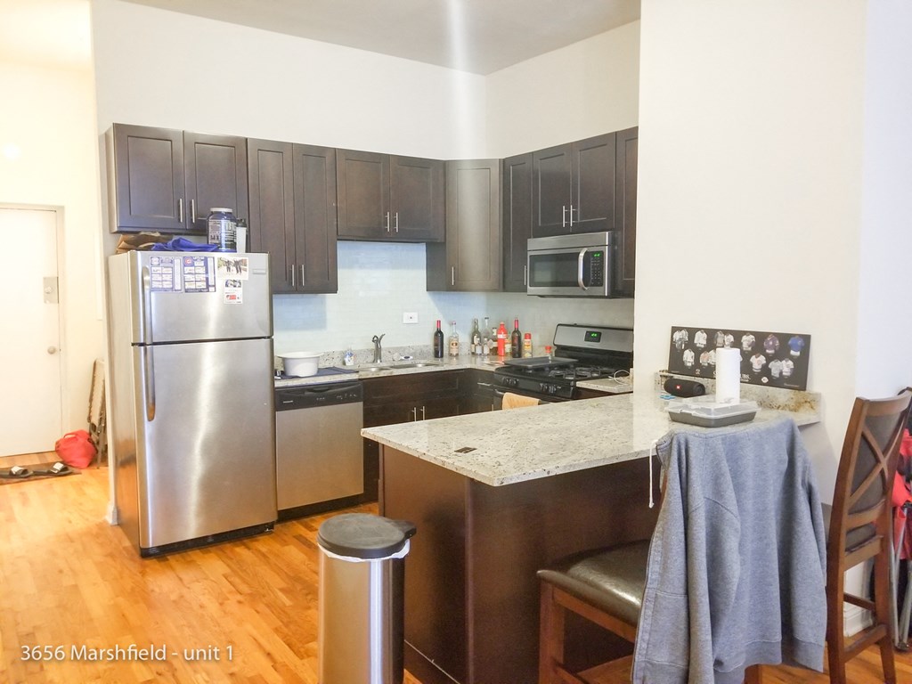a kitchen with stainless steel appliances and a marble counter top