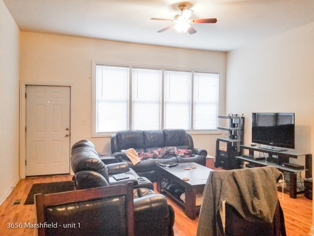 a living room with leather furniture and a tv