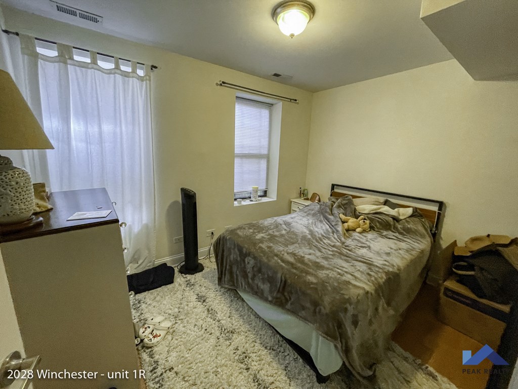 a bedroom with a bed and a dresser and a window