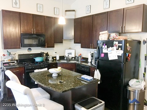 a kitchen with black appliances and a granite counter top