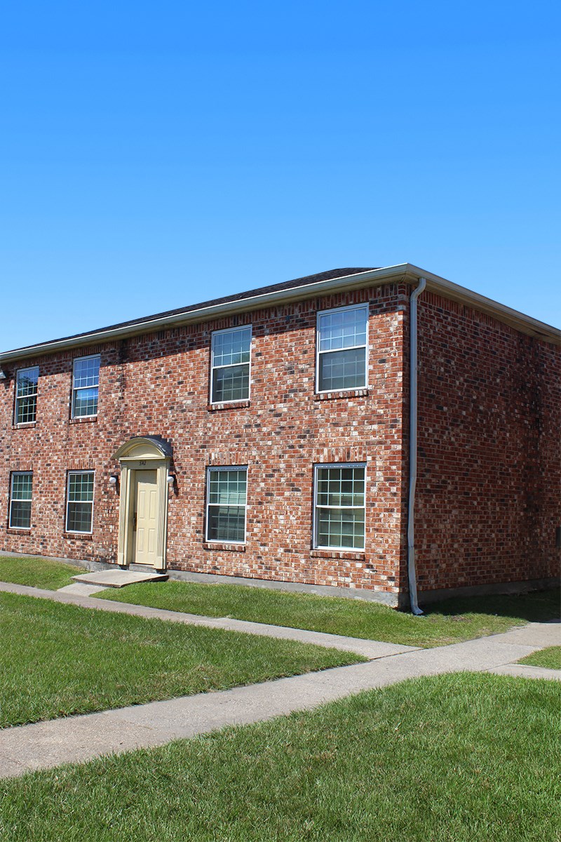 the front of a brick building with a yellow door