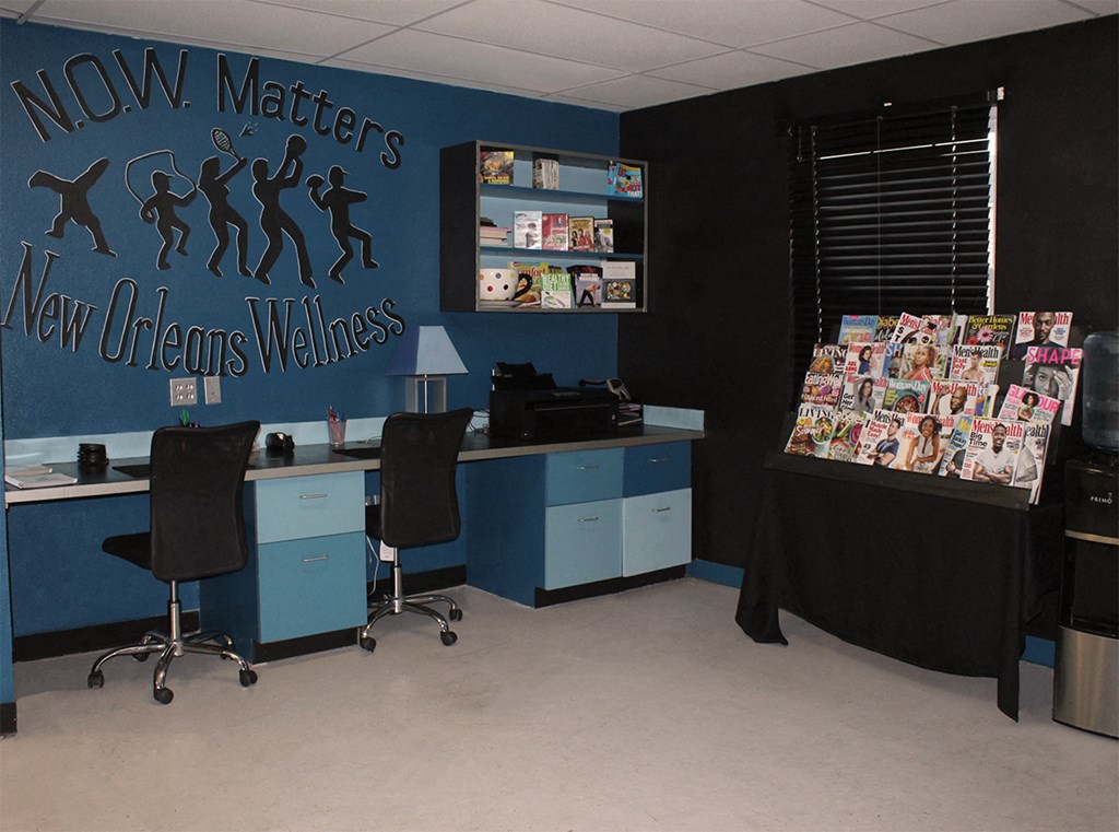 a room with a desk with two chairs and a wall with a monopoly board game