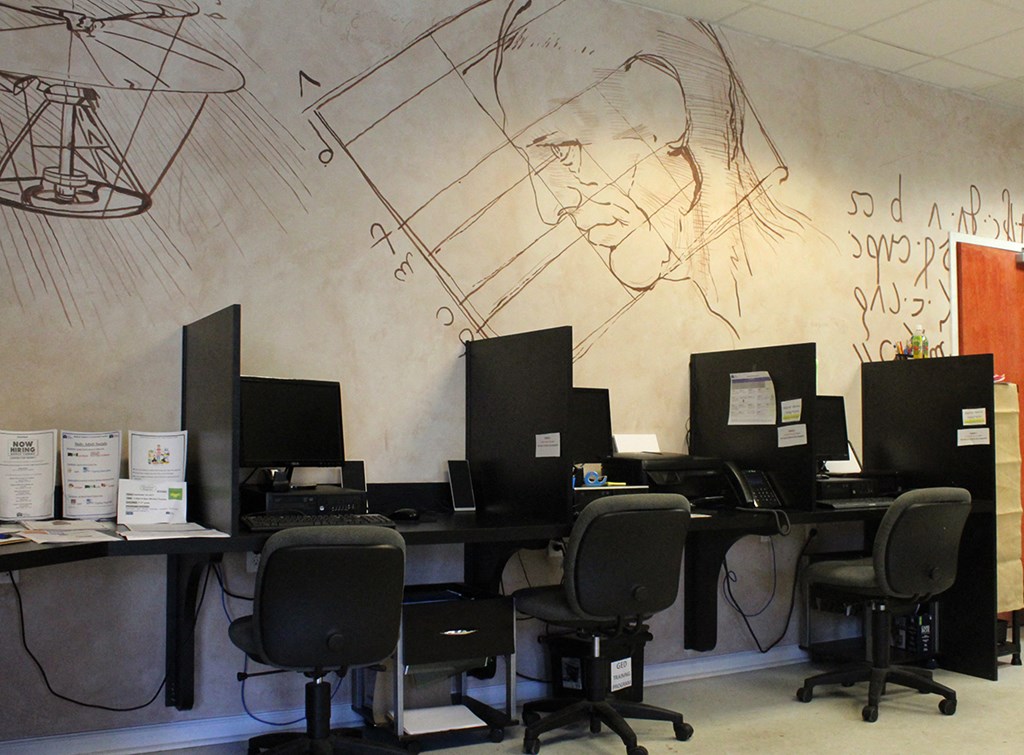 a group of computers and desks in a room with a wall withhemathemathemat
