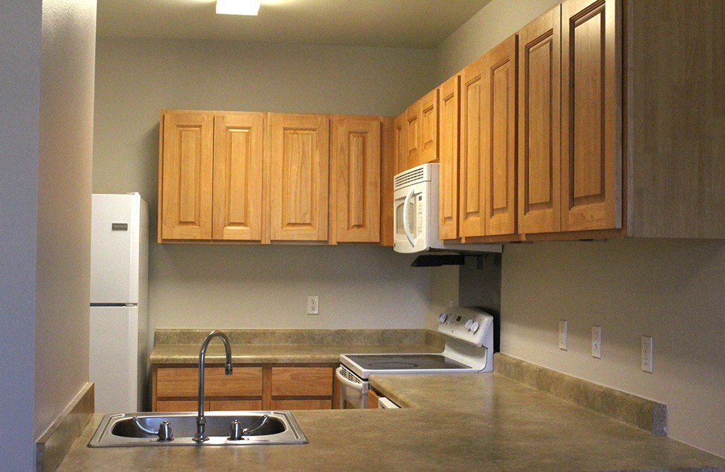 a kitchen with wooden cabinets and a stainless steel counter top