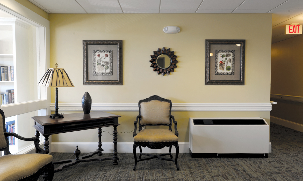 a lobby with a chair and a table with a lamp