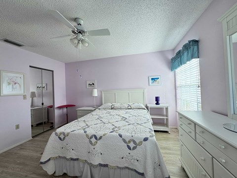 a bedroom with a bed and a ceiling fan