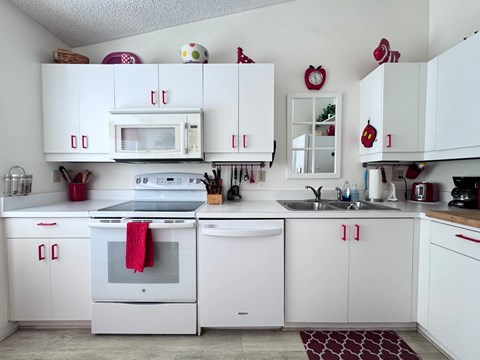 a white kitchen with white appliances and white cabinets