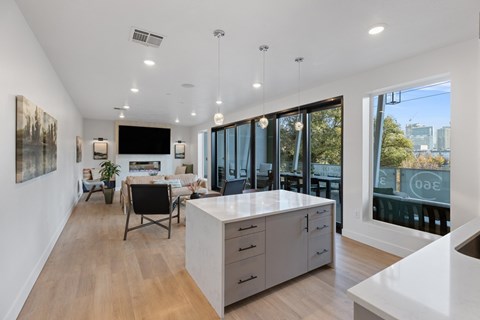 a kitchen with a large island and a dining room with a table and chairs