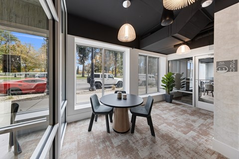 a dining room with a table and chairs in front of a window