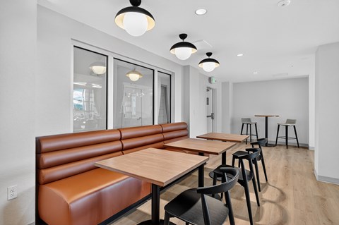 A modern dining area with brown booths and wooden tables.
