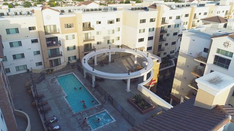A round patio with a pool in the middle of apartment buildings.