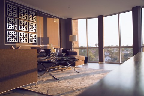A modern living room with a large window and a wooden sideboard.