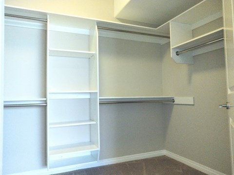 A white closet with shelves and a door.