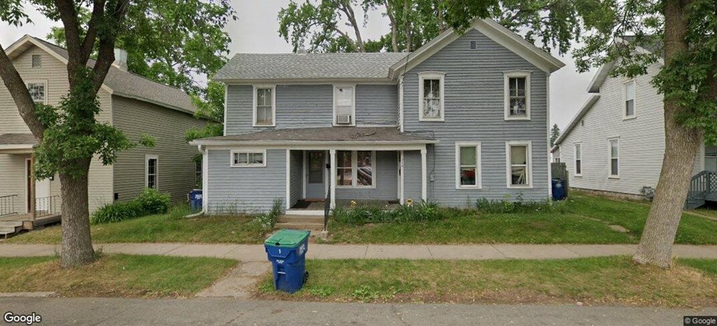 A blue house with a tree in front.