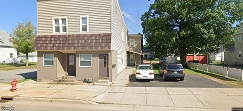 a white car parked in front of a house