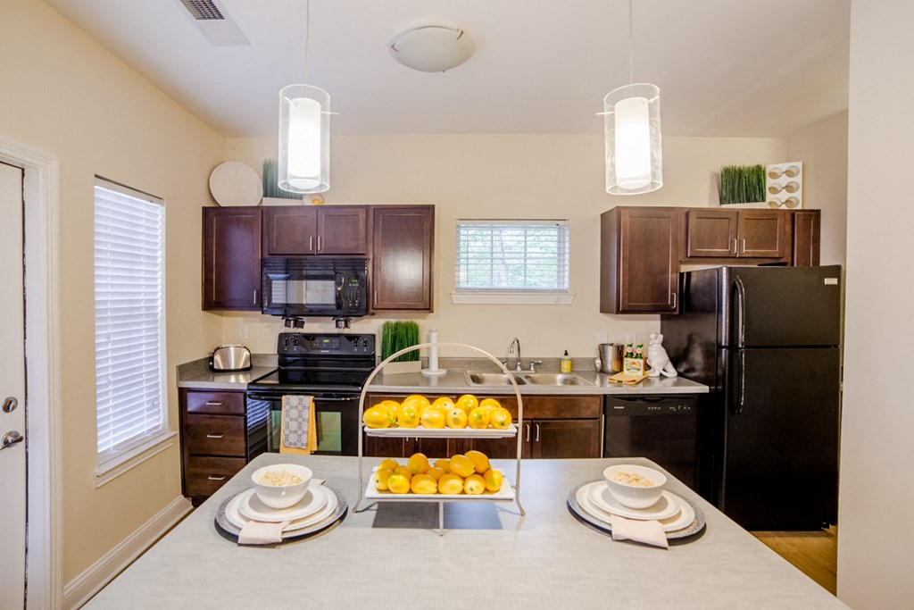 a kitchen with black appliances and a counter with fruit on it