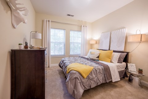 a bedroom with a bed and a dresser and a window