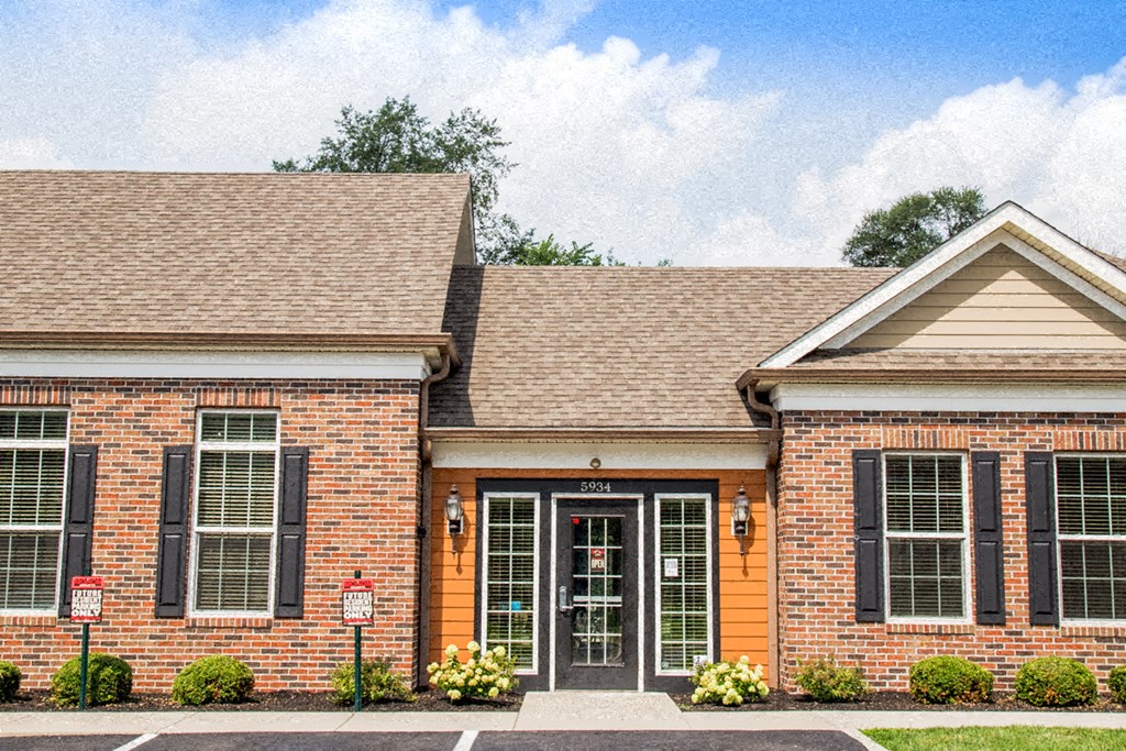 the front exterior of a brick house with black doors and windows