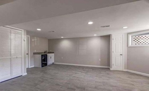 A spacious room with a grey floor and white walls.