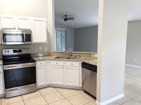 A kitchen with white cabinets and stainless steel appliances.
