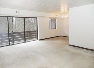 an empty living room with sliding glass doors to a patio