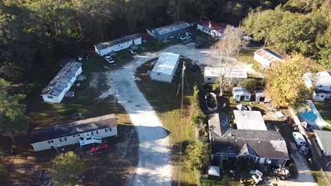 A bird's eye view of a residential area with houses and a swimming pool.