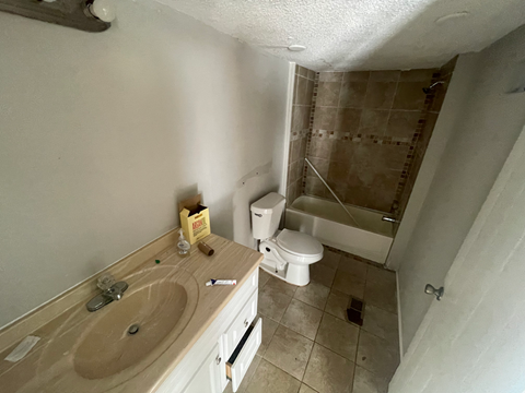 A bathroom with a toilet, sink, and shower.