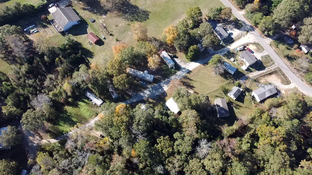 A bird's eye view of a residential area with houses surrounded by trees.