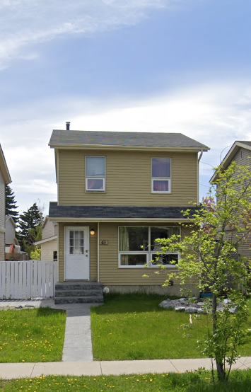 A small house with a white door and a small porch.