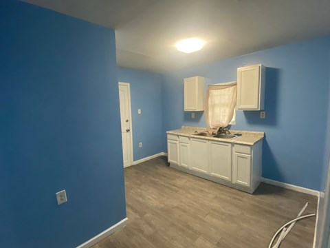 a blue room with blue walls and white cabinets and a counter