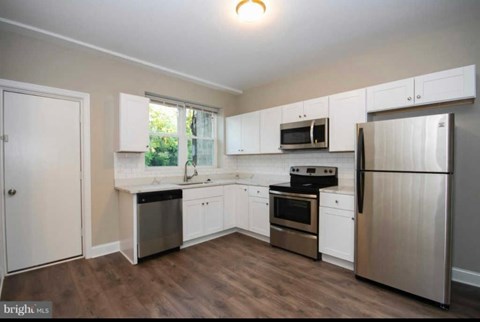 A kitchen with white cabinets and stainless steel appliances.