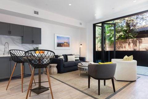 A modern living room with a black chair and a grey sofa.