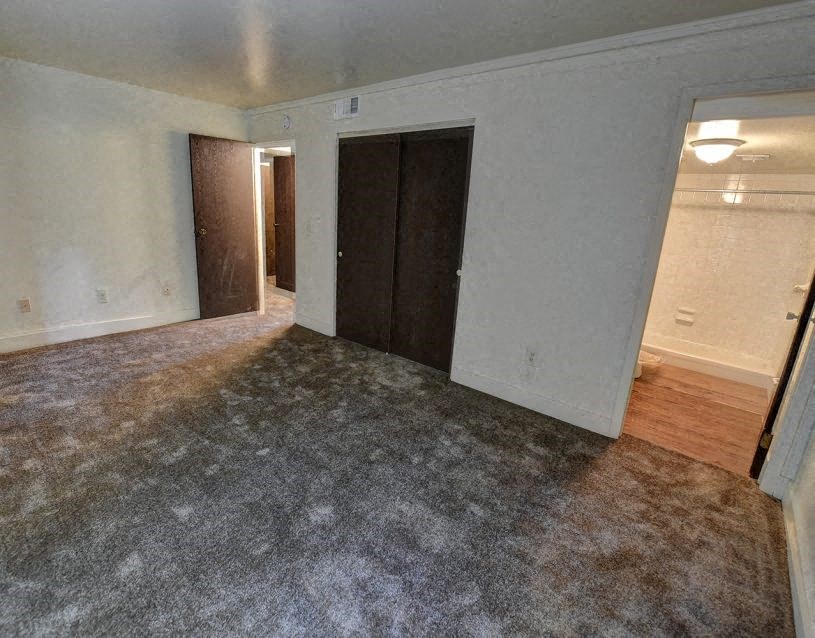 an empty living room with white walls and wood flooring