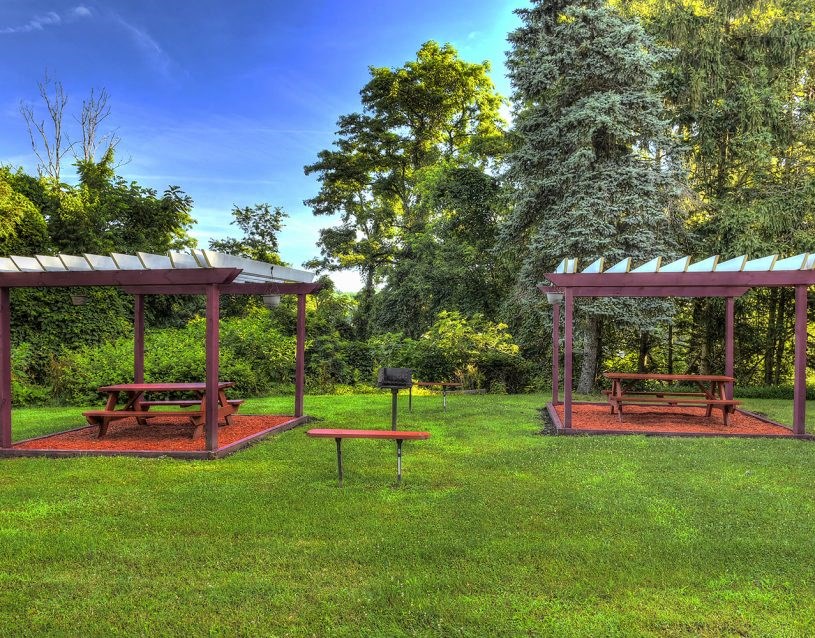 a picnic area with benches and a table in a park