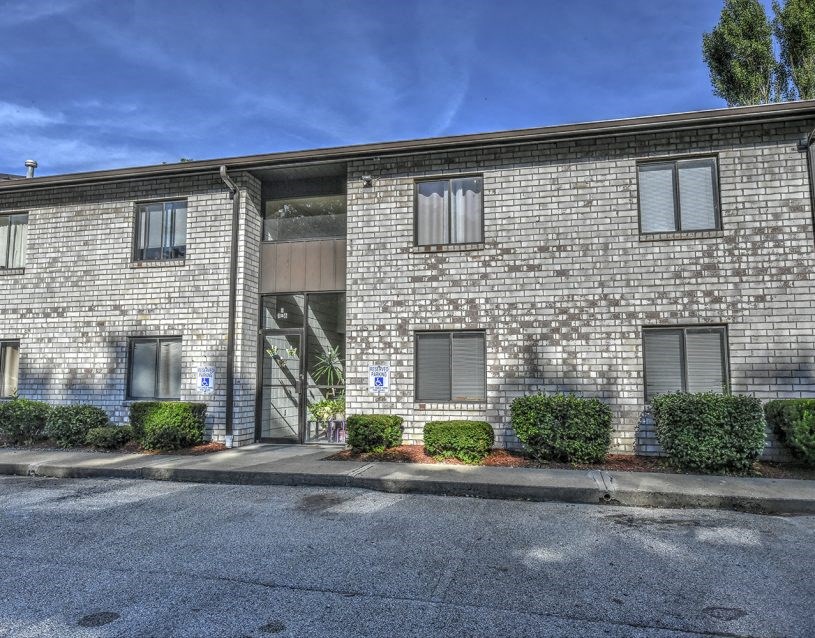 the front of a brick building with a garage door