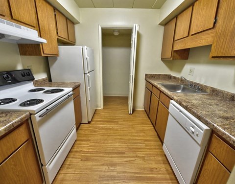 a kitchen with white appliances and wooden cabinets