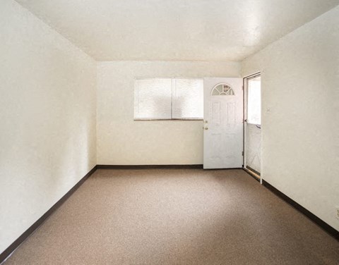 an empty room with a white door and a window
