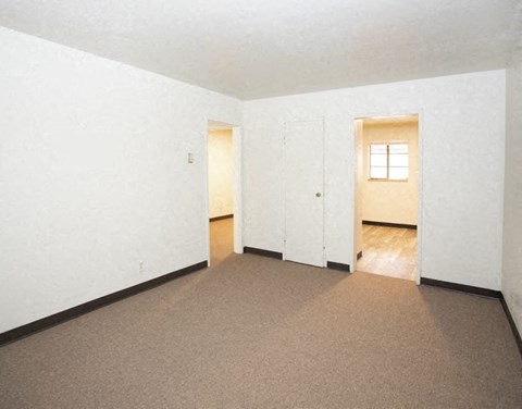 an empty living room with white walls and a carpet