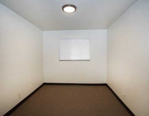 an empty room with a white wall and a window