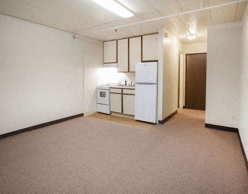 an empty kitchen with a stove and a refrigerator
