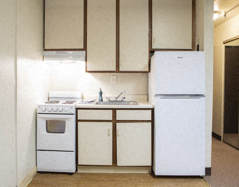 a white kitchen with a stove and a refrigerator