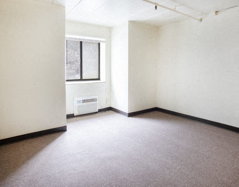 an empty room with a window and white walls