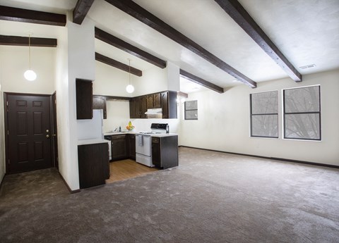 A kitchen area with a sink, stove, and cabinets.
