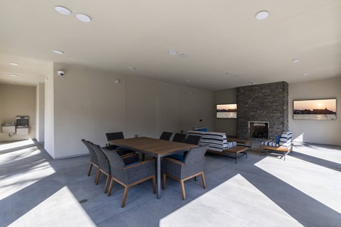a large living room with a wooden table and chairs and a fireplace