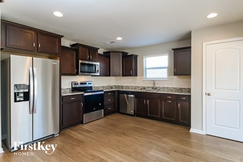 A kitchen with brown cabinets and a white refrigerator.