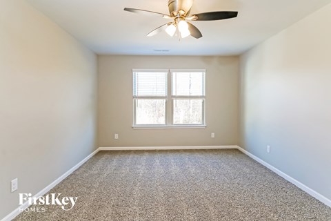 A room with a ceiling fan and a window.