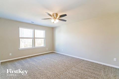 A room with a ceiling fan and a window.