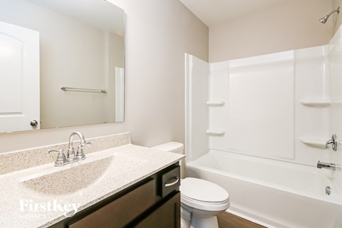 A white bathroom with a sink, toilet and bathtub.