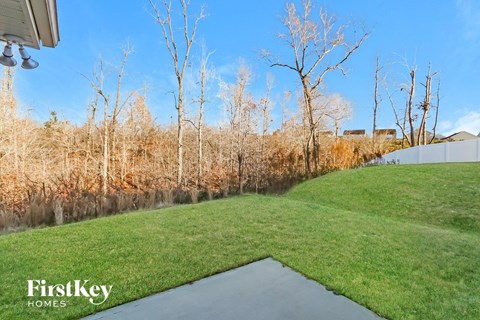 A FirstKey Homes sign is on a house in a field.