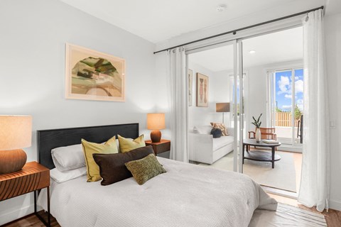 A bedroom with a large bed and a painting on the wall.